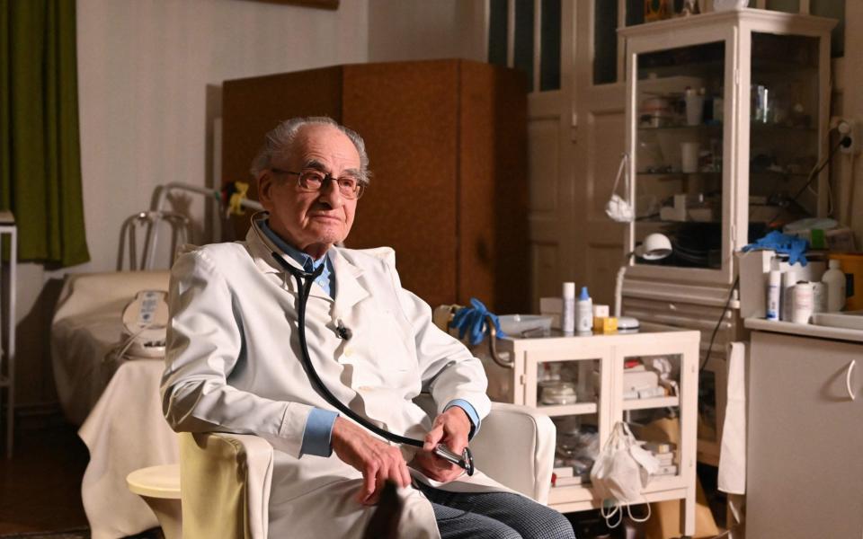 97-year-old Hungarian doctor Istvan Kormendi in his doctor's office at his home in Budapest  - Attila Kisbenedek/AFP