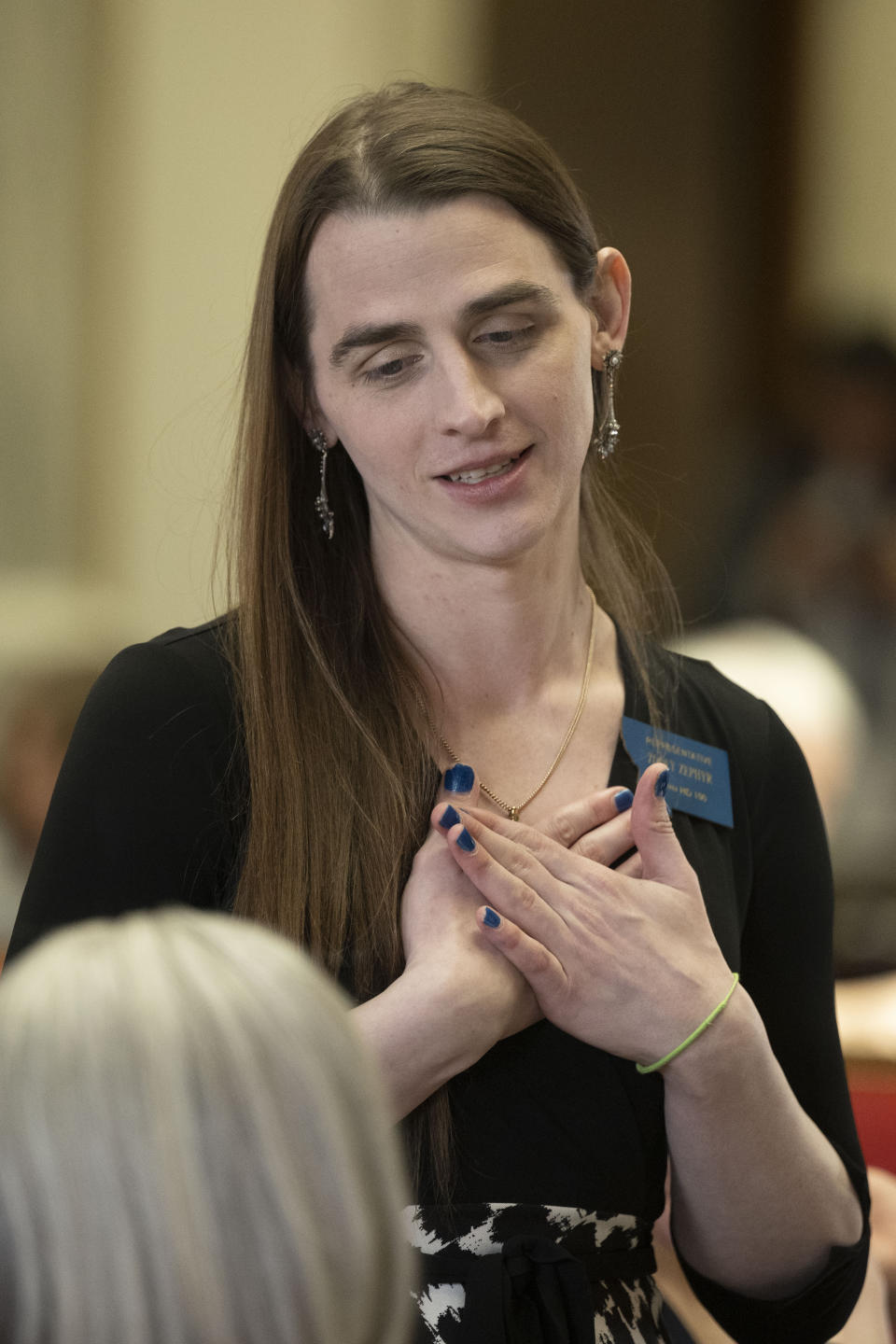 Rep. Zooey Zephyr's reacts while she talks with a fellow member of the House at the Montana State Capitol in Helena, Mont., on Wednesday, April 26, 2023. (AP Photo/Tommy Martino)