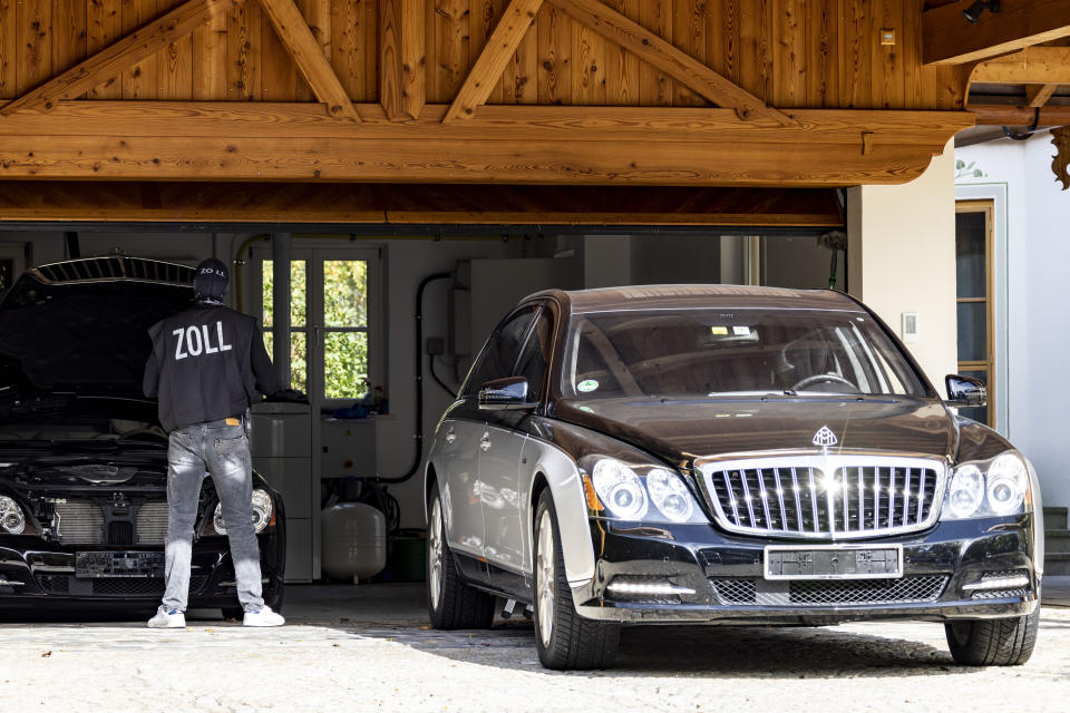 A customs officer stands in front of a Maybach at the villa on the lake in Rottach-Egern, Bavaria, Germany, Thursday Oct. 5, 2023. A special unit of police and customs officials have raided several properties of a Russian national in the southern state of Bavaria, officials said Thursday. (Christoph Reichwein/dpa via AP)