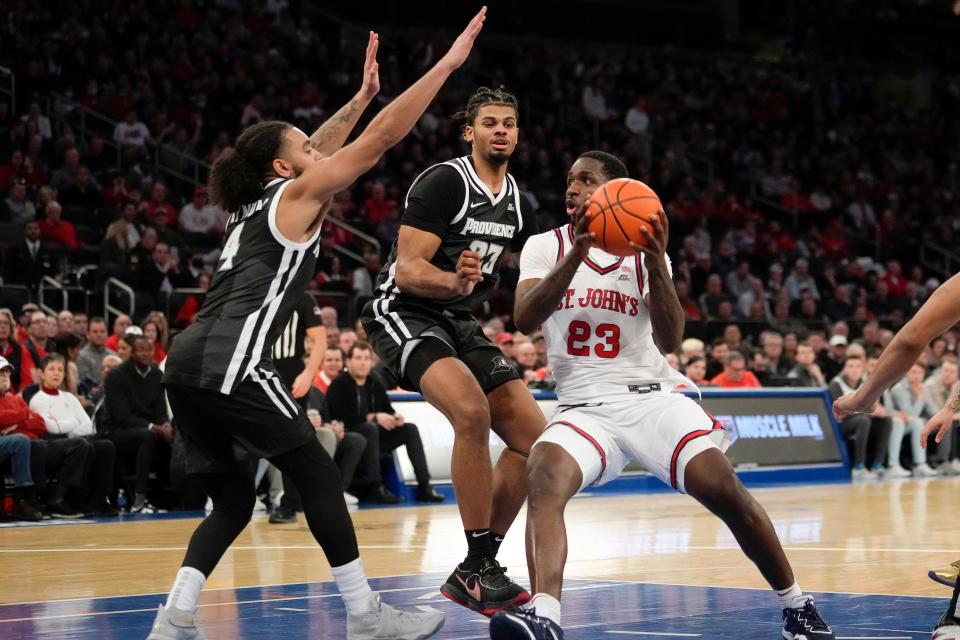 St. John's forward David Jones (23) drives to the basket as Providence guard Jared Bynum (4) and forward Bryce Hopkins (23) defend during the second half of Saturday's game at Madison Square Garden.