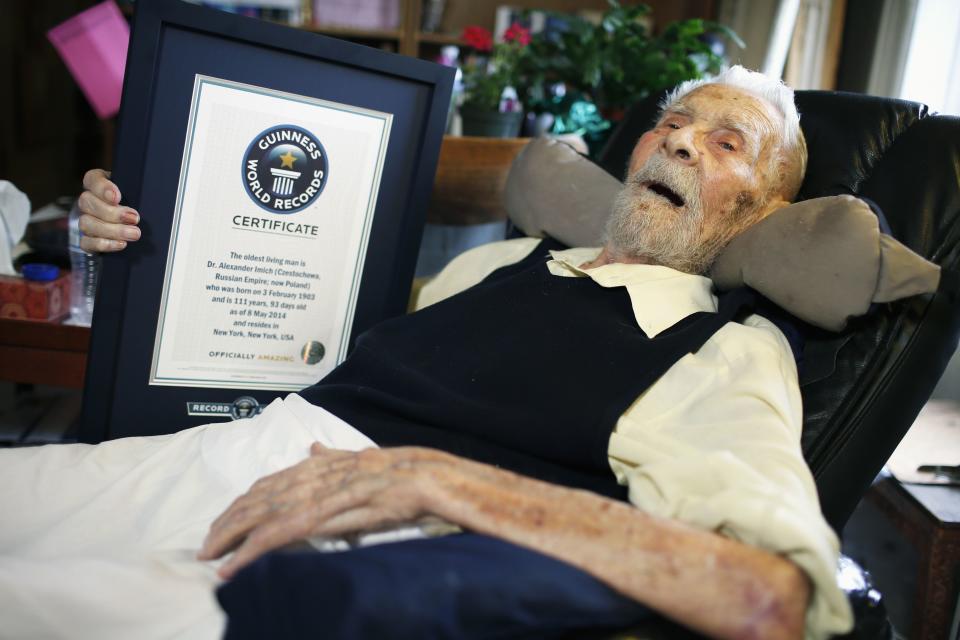 111-year-old Alexander Imich holds a Guinness World Records certificate recognizing him as the world's oldest living man during an interview with Reuters at his home on New York City's upper west side, May 9, 2014. Dr. Imich, who holds a Ph.d in Zoology, was born in Poland on February 4, 1903, fled Poland when the Nazis took over in 1939, survived a slave labor camp in Russia and moved to the United States in 1951 where he became an author on parapsychology. REUTERS/Mike Segar (UNITED STATES - Tags: SOCIETY)