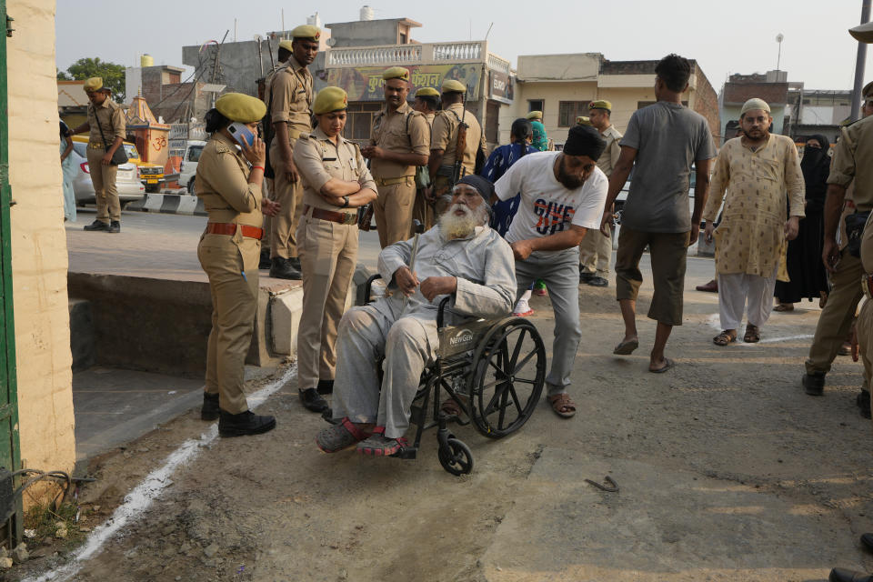 An elderly man arrives in a wheelchair to cast his vote during the fifth round of multi-phase national elections outside a polling station in Ayodhya, India, Monday, May 20, 2024. (AP Photo/Rajesh Kumar Singh)
