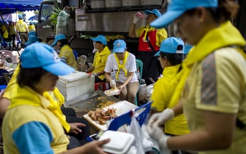 Thai volunteers prepare food in a mobile canteen at the Tham Luang cave area as rescue operations continue  - Credit: AFP/Getty Images