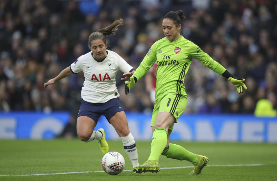 Tottenham Hotspur's Kit Graham, left, and Arsenal's goalie Manuela Zinsberger in action during their Women's Super League soccer match at the Tottenham Hotspur Stadium in London, Sunday Nov. 17, 2019. The match drew a record crowd of 38,262 for the competition on Sunday when Arsenal claimed a 2-0 victory at Tottenham. (Zac Goodwin/PA via AP)