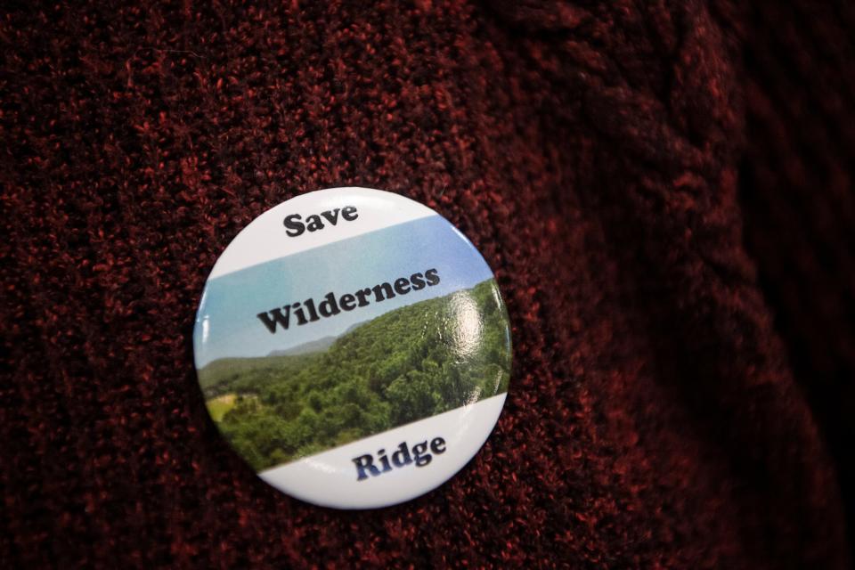 An attendee of the Board of Adjustment meeting wears a “Save Wilderness Ridge” pin, October 11, 2023.