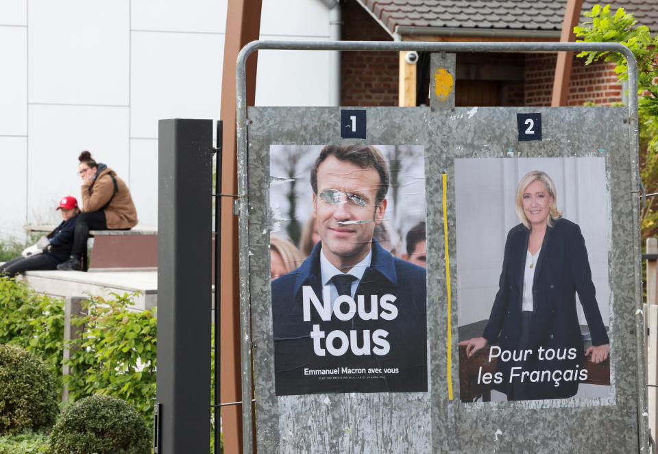 Official campaign posters of 2022 French presidential election candidates, French President Emmanuel Macron, candidate for his re-election, and Marine Le Pen, French far-right National Rally (Rassemblement National) party candidate, are displayed on an official billboard in Henin-Beaumont , France, April 23, 2022. REUTERS/Yves Herman