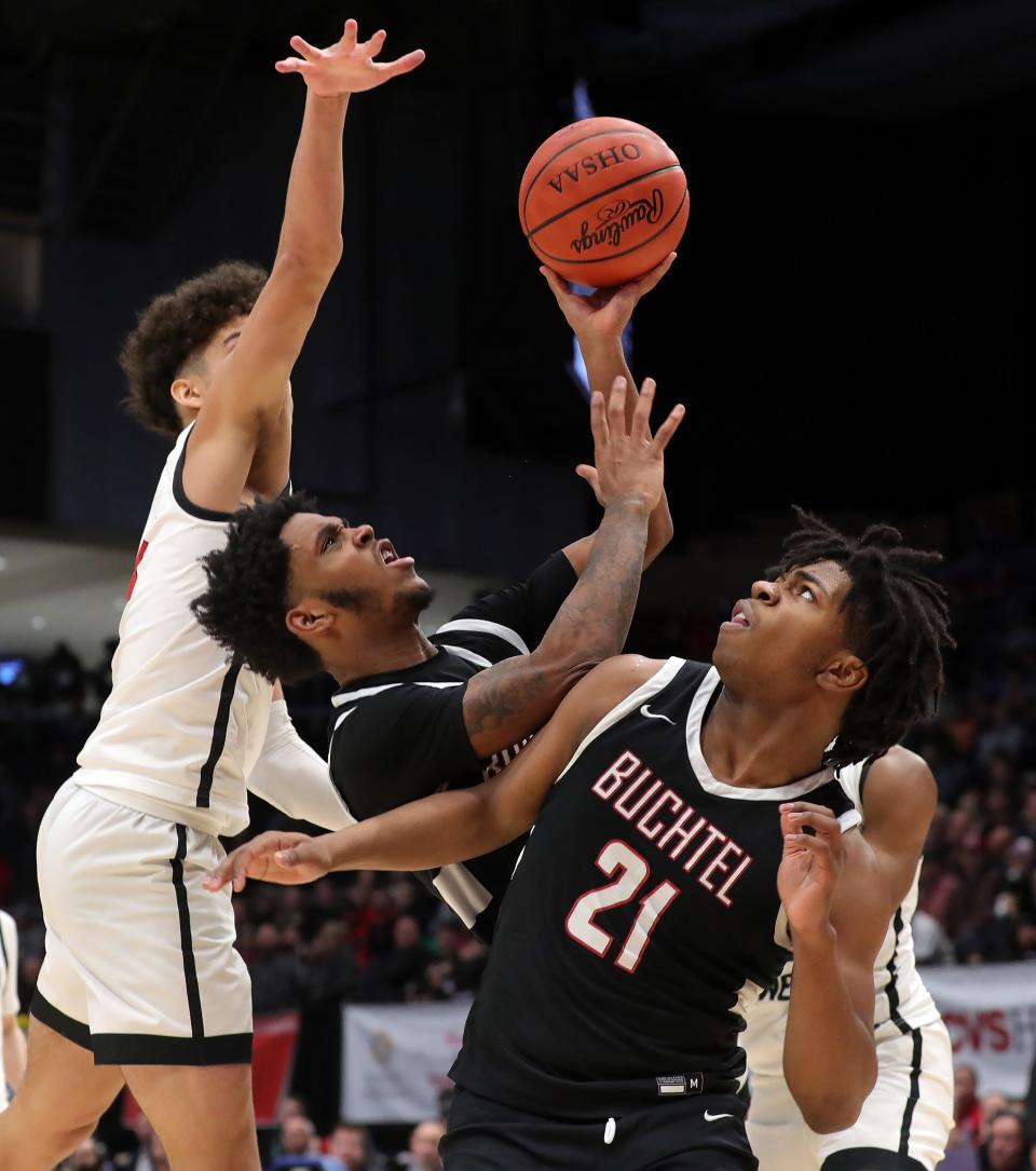 Buchtel guard Marcel Boyce Jr., center, collides with Khoi Thurmon, right, as he attempts a shot during the second half of the OHSAA Division II state final against Lutheran West, Sunday, March 19, 2023, in Dayton.