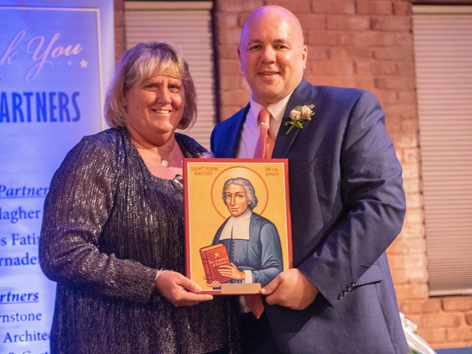 Ann MacGregor, the 2022 Catholic School Teacher of the Year, receives her award from the Manchester Diocese's Superintendent of Schools David Thibault.
