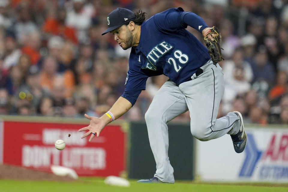 Seattle Mariners third baseman Eugenio Suarez fields a ground ball by Houston Astros' Jose Altuve during the ninth inning of a baseball game, Friday, Aug. 18, 2023, in Houston. Altuve was safe at first. (AP Photo/Eric Christian Smith)