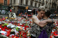 Two men react at an impromptu memorial where a van crashed into pedestrians at Las Ramblas in Barcelona, Spain August 21, 2017. REUTERS/Susana Vera