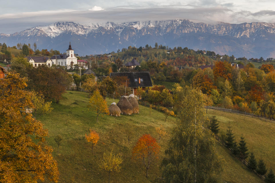 Autumn alpine landscape, with spectacular gardens and high snowy mountains in background near Bran, Magura, Transylvania, Romania. (PHOTO: Getty Images)