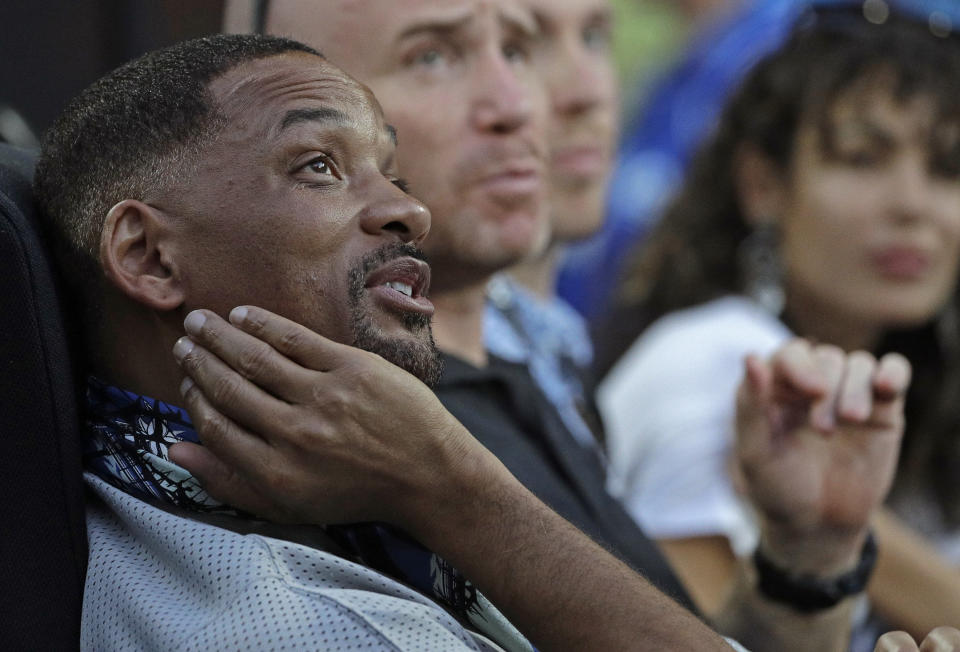 U.S. actor Will Smith, left, watches the third round match between France's Jo-Wilfried Tsonga and Australia's Nick Kyrgios at the Australian Open tennis championships in Melbourne, Australia, Friday, Jan. 19, 2018. (AP Photo/Dita Alangkara)