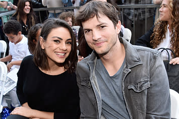 Mila smiles while sitting next to Ashton