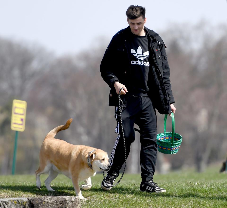 Jerrod Huhn of Canton hunts for eggs with Chase at The Paw Pad Pet Boutique in the Lake Cable Shopping Center K9 Easter Egg Hunt in Jackson Township.