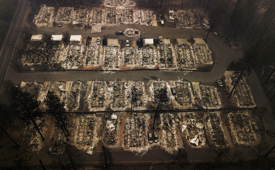 FILE - This Nov. 15, 2018, aerial file photo shows the remains of residences leveled by the Camp wildfire in Paradise, Calif. A decision was announced Friday, May 1, 2020, that Pacific Gas & Electric Corp. will sweep out three quarters of its board of directors to start with a mostly clean slate when it emerges from a bankruptcy case triggered by deadly wildfires ignited in Northern California by the utility's neglected electrical grid. (AP Photo/Noah Berger, File)