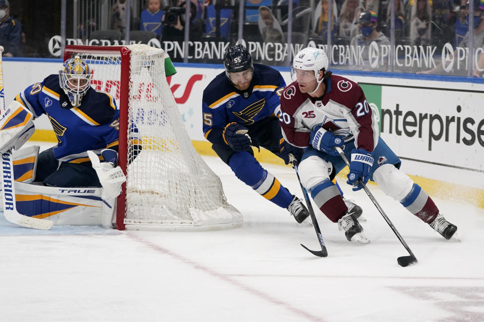 Colorado Avalanche's Brandon Saad, right, handles the puck as St. Louis Blues goaltender Jordan Binnington, left, and Colton Parayko (55) defend during the third period of an NHL hockey game Thursday, April 22, 2021, in St. Louis. (AP Photo/Jeff Roberson)