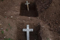 FILE - In this June 18, 2021 file photo, crosses with numbers stand inside freshly dug graves at the Inhauma cemetery where people who have died from COVID-19 are buried in Rio de Janeiro, Brazil. As of June 2021, less than 12% of Brazilians are fully vaccinated against the disease, more than 2,000 people are dying daily and experts warn Brazil may be entering its third wave. (AP Photo/Bruna Prado, File)