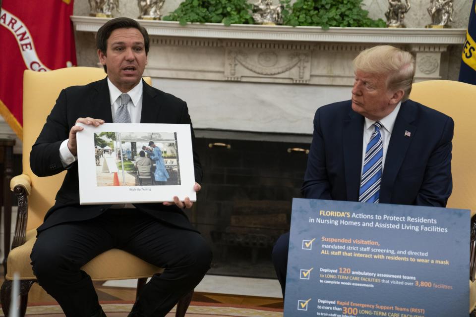 President Donald Trump listens as Gov. Ron DeSantis, R-Fla., talks about the coronavirus response during a meeting in the Oval Office of the White House on Tuesday.