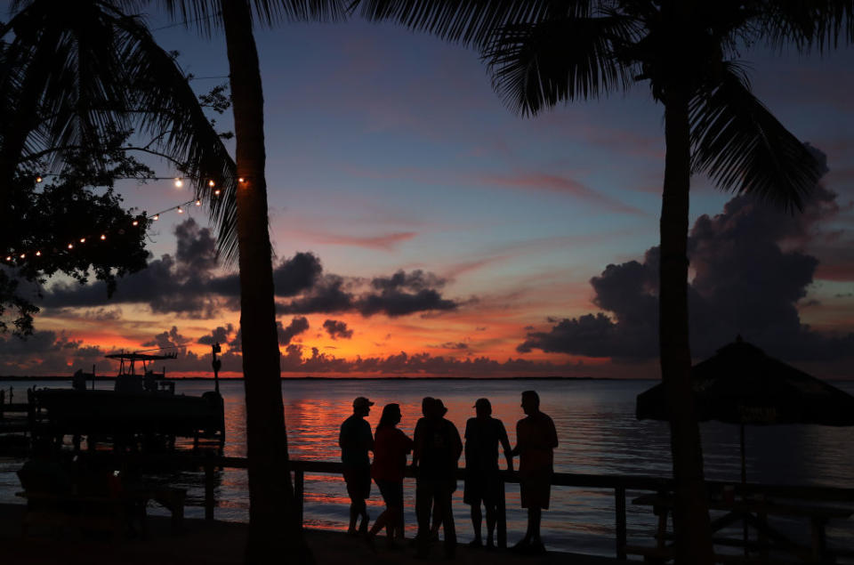 People enjoy the sunset over the water in the Gulf of Mexico during the seasonal king tides on October 27, 2019 in Key Largo, Florida.<span class="copyright">Joe Raedle—Getty Images</span>