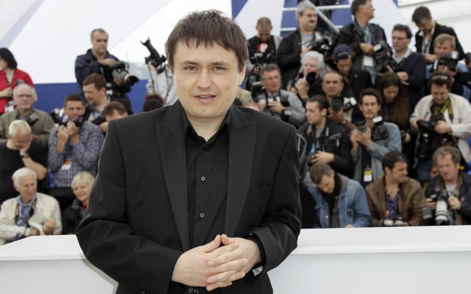 Director Director Christian Mungiu, center, smiles during a photo call for Beyond the Hills at the 65th international film festival, in Cannes, southern France, Saturday, May 19, 2012. (AP Photo/Francois Mori)