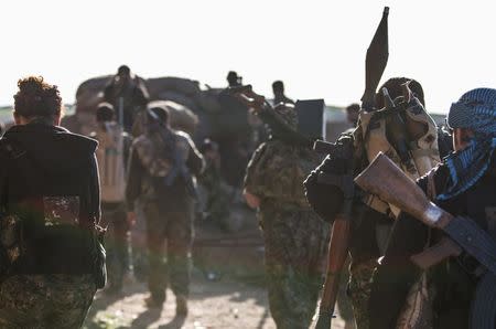 Kurdish People's Protection Units (YPG) fighters carry their weapons as they head towards their positions during what the YPG said was an offensive against them by Islamic State fighters, in the western countryside of Ras al-Ain March 10, 2015. REUTERS/Rodi Said