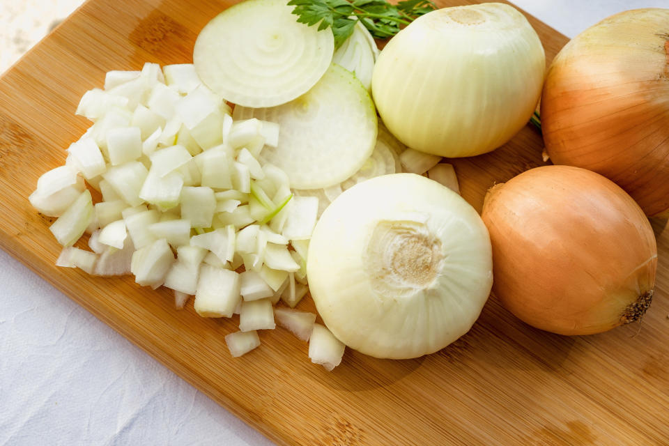 whole and chopped onions on a cutting board