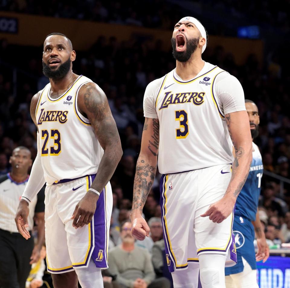 Lakers star Anthony Davis yells after scoring and drawing a foul while standing next to LeBron James.