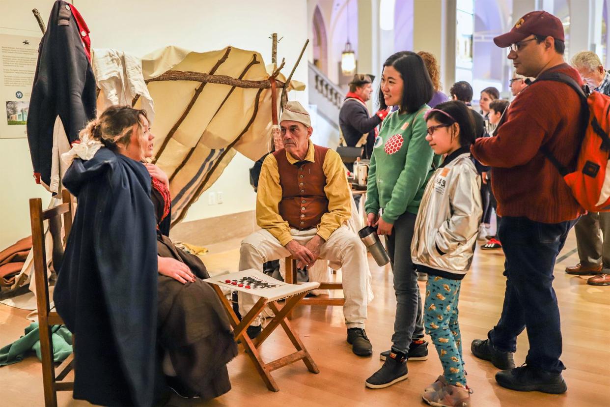 a group of people looking at a person sitting in a chair