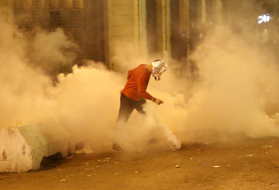 An anti-government protester runs in the middle of a tear gas smoke that fired by the riot police, during a protest near the parliament square, in downtown Beirut, Lebanon, Sunday, Dec. 15, 2019. Lebanese security forces fired tear gas, rubber bullets and water cannons Sunday to disperse hundreds of protesters for a second straight day, ending what started as a peaceful rally in defiance of the toughest crackdown on anti-government demonstrations in two months. (AP Photo/Hussein Malla)