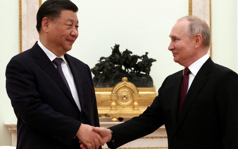 Russian President Vladimir Putin shakes hands with Chinese President Xi Jinping - Sputnik/Sergei Karpukhin/Pool via REUTERS