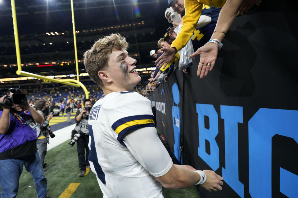 Michigan quarterback J.J. McCarthy (9) celebrates with fans after the Big Ten championship NCAA college football game against Iowa, Saturday, Dec. 2, 2023, in Indianapolis. Michigan won 26-0. (AP Photo/AJ Mast)