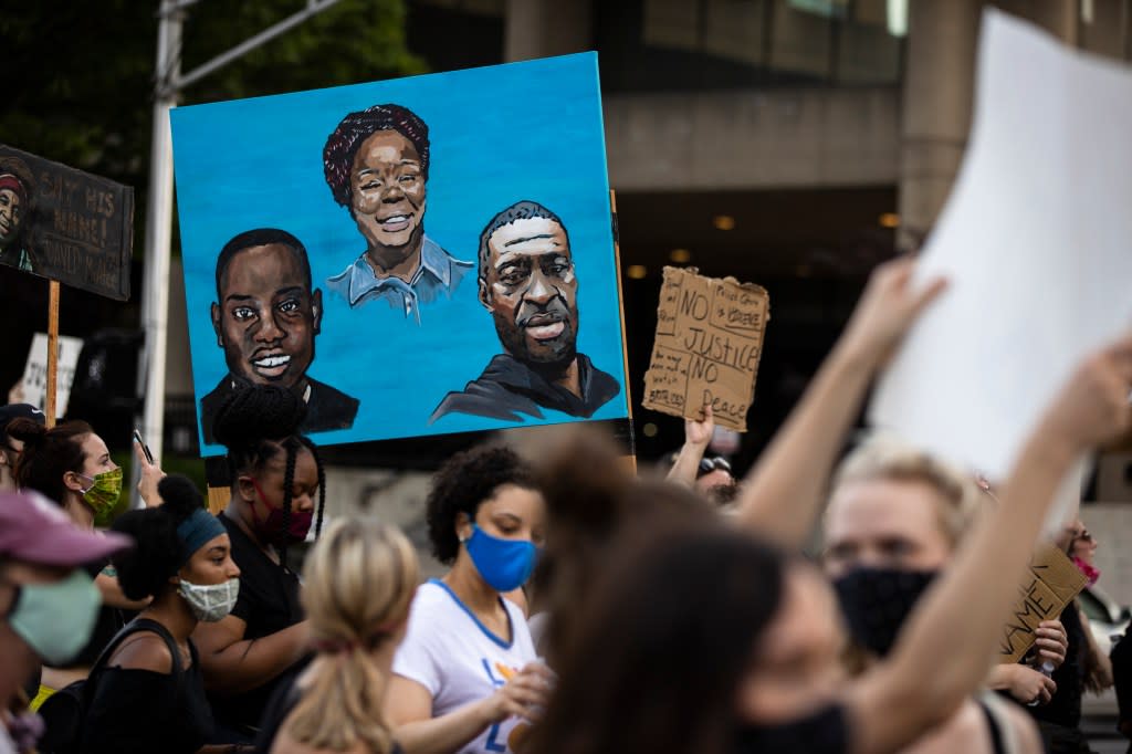 Protesters carry a painting of (L-R) Ahmaud Arbery, Breonna Taylor and George Floyd while marching on June 5, 2020 in Louisville, Kentucky. (Photo by Brett Carlsen/Getty Images)