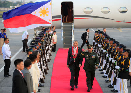 Singapore Prime Minister Lee Hsien Loong (C) reviews honour guards upon arrival at the Manila International airport in Pasay city, metro Manila, Philippines April 28, 2017. REUTERS/Romeo Ranoco