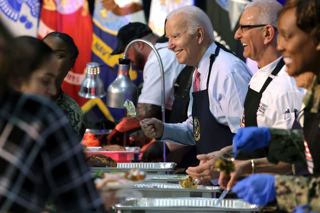 <p>Alex Wong/Getty </p> President Joe Biden serves service members and military families during a "Friendsgiving" dinner on Nov. 19