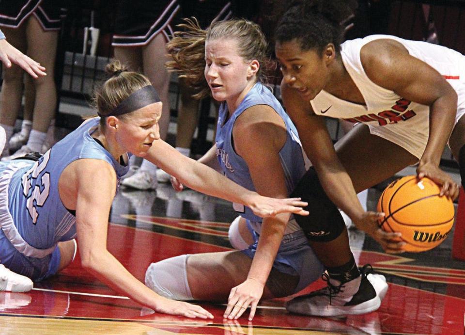 Elise Cone, left, and her twin sister Mary battle for a loose ball during their Bartlesville playing days.