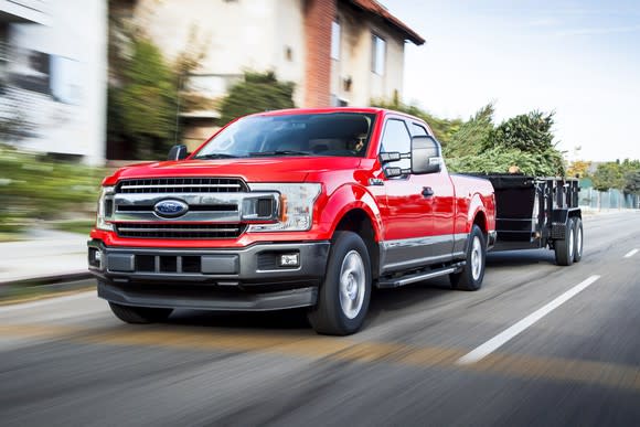 A red 2018 Ford F-150 pulling a trailer.