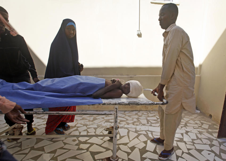 A female relative looks on as a wounded man is brought into Medina Hospital after a car bomb attack at a busy junction in the Wadajir district of the capital Mogadishu, Somalia Monday, Nov. 26, 2018. Somalia was hit by two violent attacks Monday, one killing an Islamic cleric and 17 of his followers for playing music and a second killing at least six people in a car bomb blast in the capital, Mogadishu, police said. (AP Photo/Farah Abdi Warsameh)
