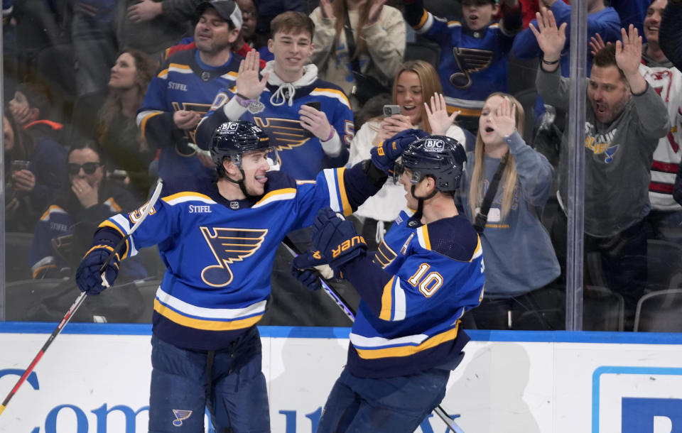 St. Louis Blues' Jakub Vrana, left, is congratulated by Brayden Schenn (10) after scoring the game-winning goal in overtime of an NHL hockey game against the Vancouver Canucks Tuesday, March 28, 2023, in St. Louis. (AP Photo/Jeff Roberson)