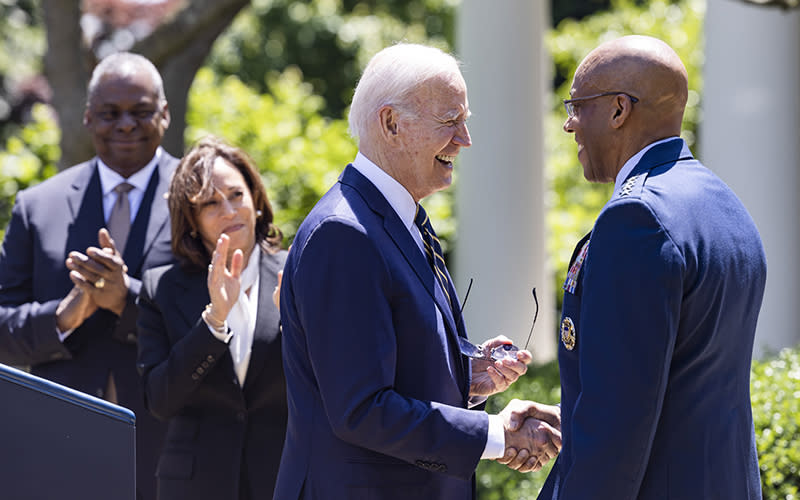 President Biden shakes hands with Gen. Charles Q. Brown Jr. as Secretary of Defense Lloyd Austin and Vice President Harris applaud