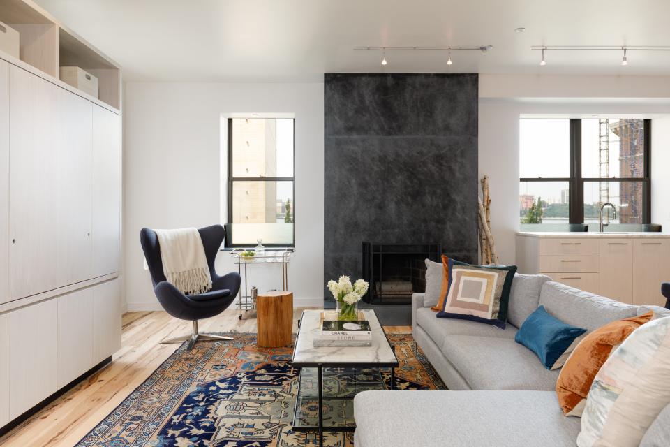 Exposed wood on one side of the open-plan living space and a dark soapstone fireplace on the other provide plenty of texture.