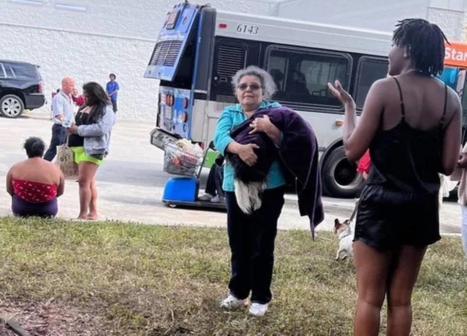 Nidia Lau, de 61 años, sostiene a su shih tzu Banti, de 18 años, cerca de su complejo de apartamentos el sábado. Lau fue una de las 105 personas desplazadas tras el incendio que afectó a decenas de unidades en un edificio de apartamentos de dos pisos en 395 NW 177 St. en Miami Gardens.