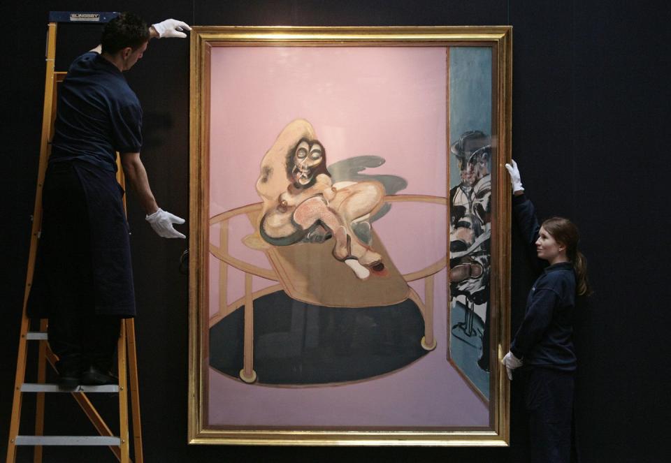 sotheby's employees hold a painting enti