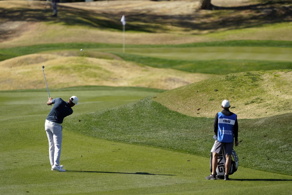 Tony Finau, left, hits from the third fairway during the final round of The American Express golf tournament on the Pete Dye Stadium Course at PGA Wes,t Sunday, Jan. 24, 2021, in La Quinta, Calif. (AP Photo/Marcio Jose Sanchez)