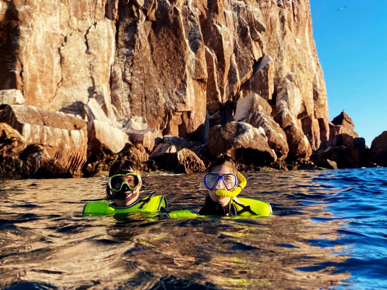 Two people snorkel in the rocky waters off of Baja.