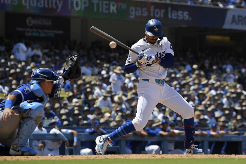 Los Angeles Dodgers' Mookie Betts, right, is hit by a pitch as Kansas City Royals catcher Freddy Fermin catches during the seventh inning of a baseball game Sunday, June 16, 2024, in Los Angeles. (AP Photo/Mark J. Terrill)