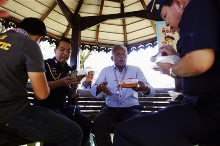 Anti-government protest leader Suthep Thaugsuban (C) shares a meal with officers after his protesters broke into the grounds of an air force compound in Bangkok May 15, 2014. REUTERS/Damir Sagolj