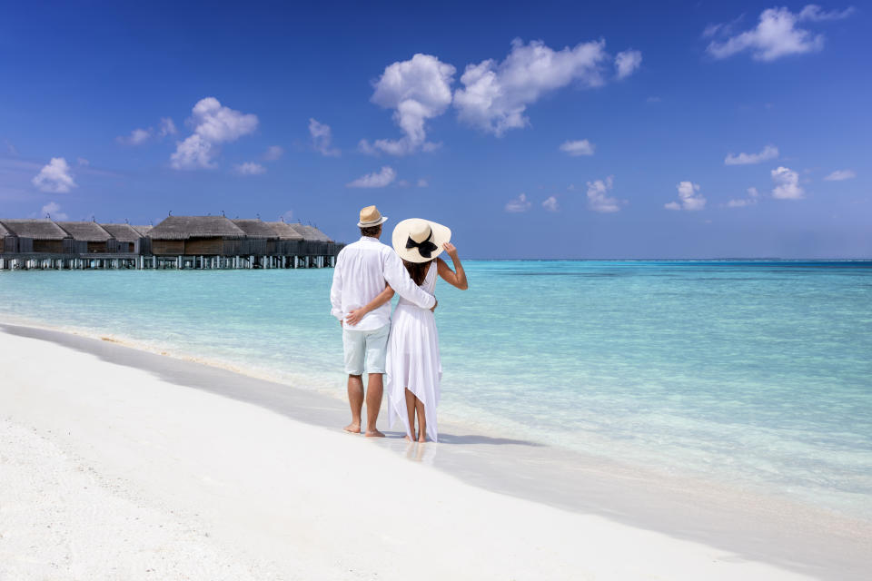 A couple looking into the water on their honeymoon