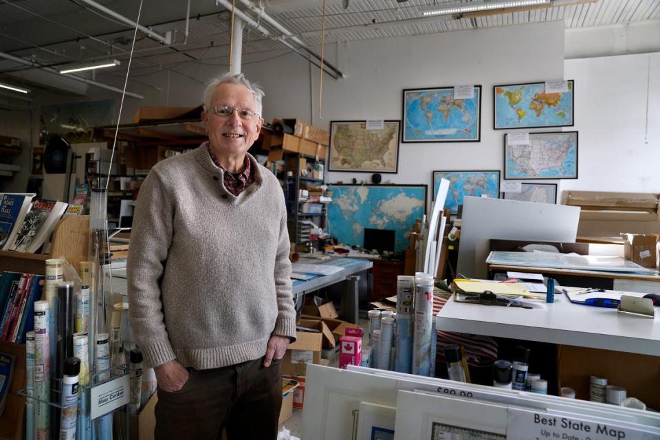 Andrew Nosal, owner of The Map Center, surrounded by the many varieties of maps in his Pawtucket store.