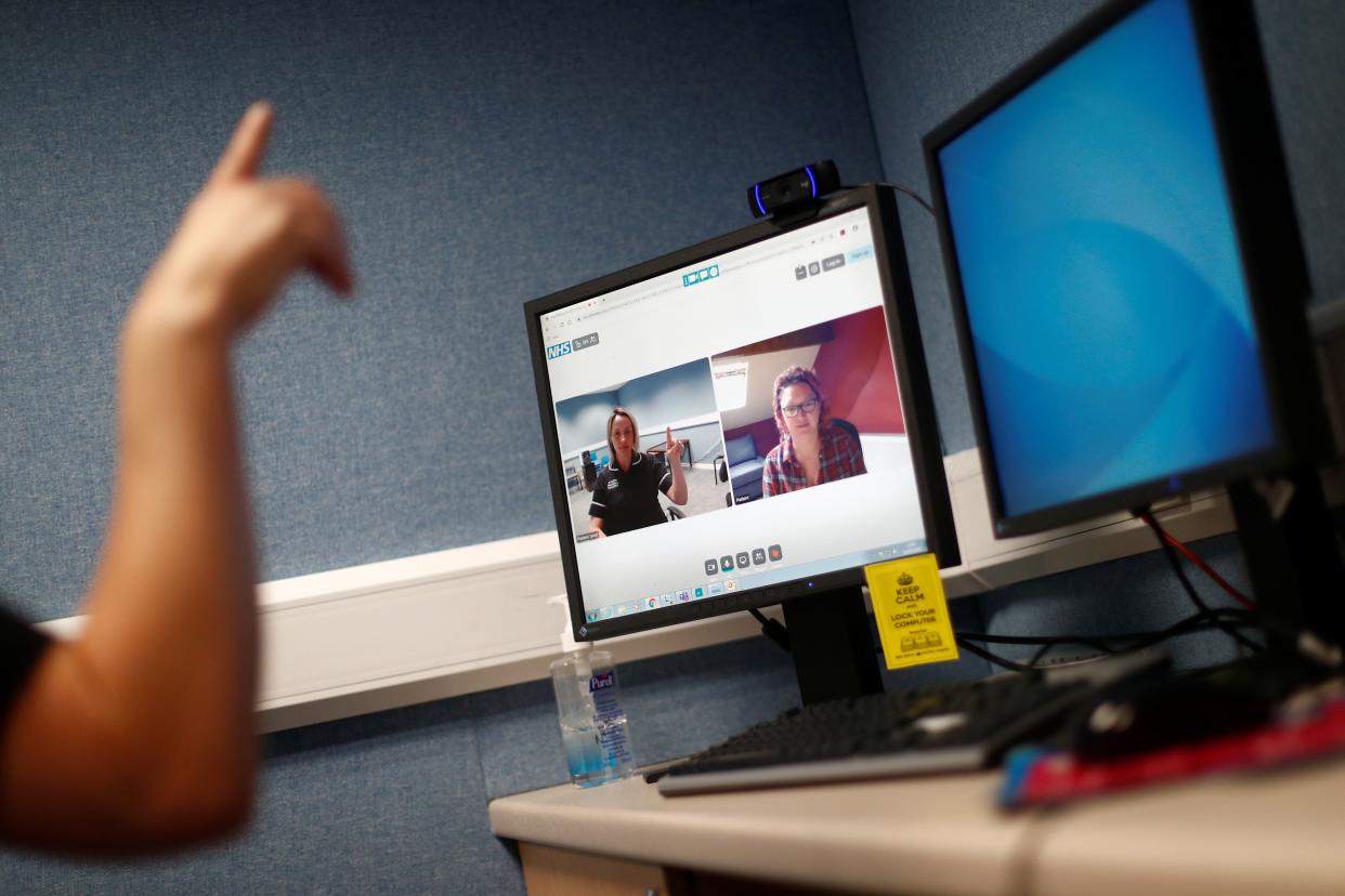 Alison McLoughlin conducts a therapy session with a patient using the Zoom app on May 14, 2020. (Photo by HANNAH MCKAY/POOL/AFP)