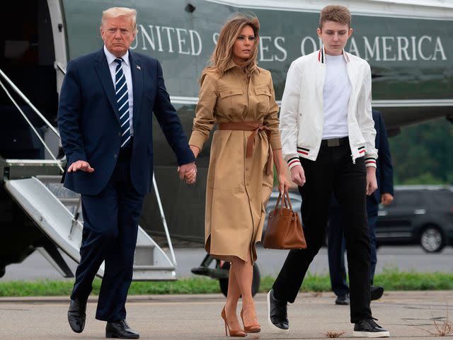 <p>JIM WATSON/AFP/Getty</p> Former US President Donald Trump (L) walks with First Lady Melania Trump and their son Barron, 2020